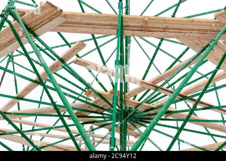 Gerüst mit einem Holzdeck in Form einer stehenden Plattform als Struktur eines radialen Objekts. Teil des Rahmens der Stadt Weihnachtsbaum Stockfoto