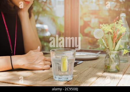 Gesunde Ernährung der Frau Trinkwasser mit Zitrone im Restaurant. Stockfoto