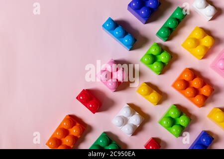 Spielzeug Blöcke Rahmen, lebendige Kunststoff Bausteine, Gruppe von bunten Spiel pieces.Colorful Baby Spielzeug auf rosa Hintergrund. Entwicklung von Blöcken. Kreativ Stockfoto