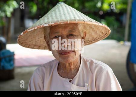 Sagaing/Myanmar - 3. Oktober 2019: Ein Portrait von burmesischen alten Frauen in traditioneller Kleidung und gewebten Hüten. Stockfoto