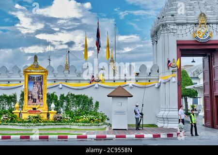 Monsun Wolken über dem Eingang zum Grand Palace & Wat Phra Kaew, mit einer königlichen Wache und ein Porträt von König Maha Vajiralongkorn; Bangkok, Thailand Stockfoto