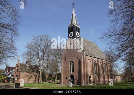 Schöne, kleine reformierte Kirche des niederländischen Dorfes Schoorl (18. Jahrhundert) und das ehemalige, kleine Rathaus (1601). Niederlande, April Stockfoto