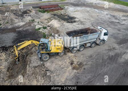 Bagger lädt Sand in einen LKW Stockfoto