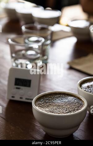 Kaffeesatz mit heißem Wasser in keramischen Tasse auf dem Tisch bereitet sich für professionelle Q Grader zu testen und zu überprüfen Qualität von Kaffee. Stockfoto