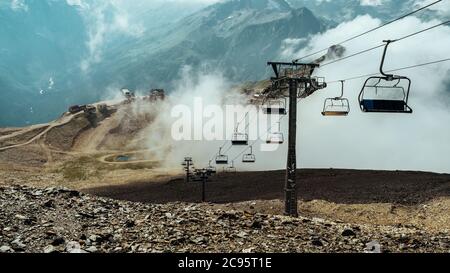 Seilbahn in der Nähe von Rauch in felsigen Landschaft. Moderne Seilbahn auf steinigem Boden in der Nähe von dicken Rauch in erstaunlichen bergigen Gelände Stockfoto