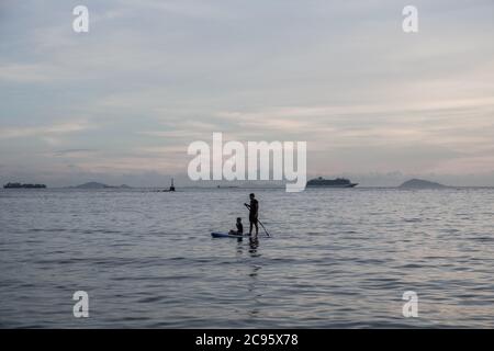 Hongkong, China. Juli 2020. Ein Mann durchstreift ein Paddelbrett in der Bucht von Yung Shue Wan, Lamma Island in Hong Kong. Kredit: SOPA Images Limited/Alamy Live Nachrichten Stockfoto