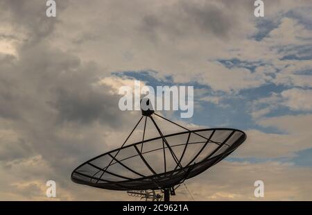 Schwarzer Satellitenschüssel-Antennenempfänger auf blauem Himmel Hintergrund für Kommunikations- und Medienindustrie, symbolisiert globale Kommunikation. Free Cop Stockfoto