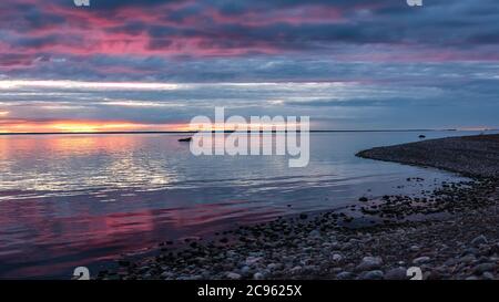 Sonnenuntergang über der schwedischen Ostsee ein später Abend mit Schiffen am Horizont, die darauf warten einzufahren Stockfoto