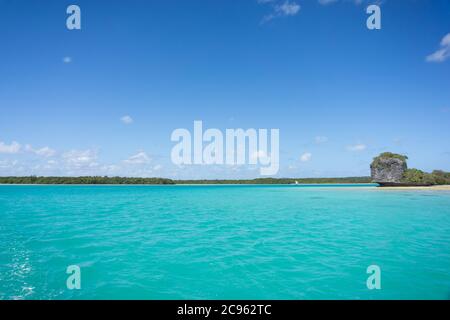 Wunderschöne Seeslandschaft der UPI Bay, Pines Island, neukaledonien: Türkisfarbene Lagune, typische Felsen, üppige Vegetation, blauer Himmel Stockfoto