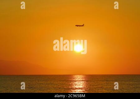 Sonnenaufgang über dem Meer. Flugzeug kommt an Land. Stockfoto