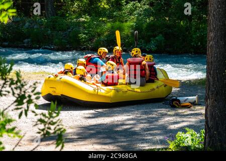 Kinder sitzen im Gummiboot vor dem Rafting auf dem kleinen Dorf Le Casset, am Fluss Guisane, Serre Chevalier, in der Nähe von Briancon, Ecrins, Frankreich Stockfoto