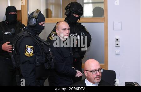 29. Juli 2020, Sachsen-Anhalt, Magdeburg: Der Angeklagte Stephan Balliet wird vor dem vierten Verhandlungstag von Justizbeamten in den Gerichtssaal gebracht. Die Bundesanwaltschaft wirft dem Mann 13 Verbrechen vor, darunter Mord und versuchten Mord. Der Attentäter hatte am 9. Oktober 2019, dem höchsten jüdischen Feiertag Jom Kippur, versucht, in der Synagoge in Halle ein Blutbad zu verursachen. Foto: Ronny Hartmann/dpa Stockfoto