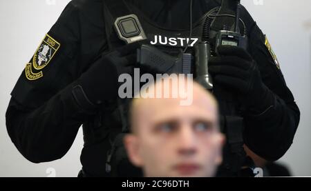 29. Juli 2020, Sachsen-Anhalt, Magdeburg: Vor dem vierten Verhandlungstag steht hinter dem Angeklagten Stephan Balliet ein Justizbeamter im Gerichtssaal. Die Staatsanwaltschaft wirft dem Mann 13 Verbrechen vor, darunter Mord und versuchten Mord. Der Attentäter hatte am 9. Oktober 2019, dem höchsten jüdischen Feiertag Jom Kippur, versucht, in der Synagoge in Halle ein Blutbad zu verursachen. Foto: Ronny Hartmann/dpa Stockfoto