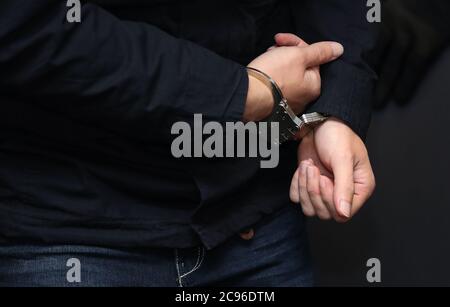 29. Juli 2020, Sachsen-Anhalt, Magdeburg: Der Angeklagte Stephan Balliet wird vor dem vierten Verhandlungstag in Handschellen in den Gerichtssaal gebracht. Die Bundesanwaltschaft wirft dem Mann 13 Verbrechen vor, darunter Mord und versuchten Mord. Der Attentäter hatte am 9. Oktober 2019, dem höchsten jüdischen Feiertag Jom Kippur, versucht, in der Synagoge in Halle ein Blutbad zu verursachen. Foto: Ronny Hartmann/dpa Stockfoto