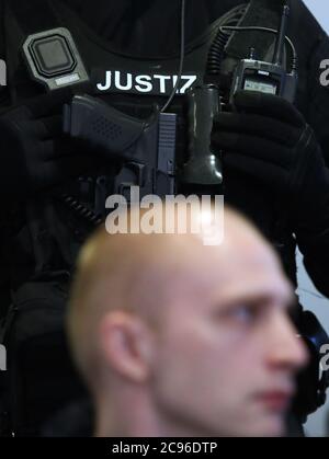 29. Juli 2020, Sachsen-Anhalt, Magdeburg: Vor dem vierten Verhandlungstag steht hinter dem Angeklagten Stephan Balliet ein Justizbeamter im Gerichtssaal. Die Staatsanwaltschaft wirft dem Mann 13 Verbrechen vor, darunter Mord und versuchten Mord. Der Attentäter hatte am 9. Oktober 2019, dem höchsten jüdischen Feiertag Jom Kippur, versucht, in der Synagoge in Halle ein Blutbad zu verursachen. Foto: Ronny Hartmann/dpa Stockfoto