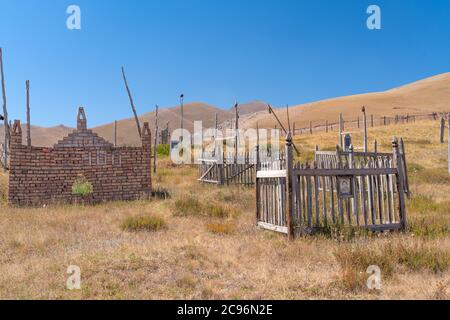 Der Blick auf den alten traditionellen Friedhof in einem kleinen abgelegenen Dorf in Kirgisistan Stockfoto