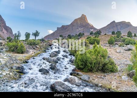 Die schöne Bergwanderstraße mit klarem blauen Himmel und felsigen Hügeln und der Blick auf den Alaudin See in Fann Berge in Tadschikistan Stockfoto