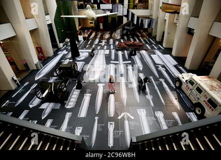 Ein Mitarbeiter des Imperial war Museum steht auf einem Teil der Oberfläche von Ai Weiweis 'Geschichte der Bomben' während einer Fotoausstellung für das neue Werk des chinesischen Künstlers, die im Imperial war Museum in London zu sehen ist. Das Kunstwerk zeigt 50 maßstabsgemaßte Bomben vom Ersten Weltkrieg bis in die Gegenwart und deckt die Böden und Wände des IWM-Atriums auf einer Fläche von über 1,000 Quadratmetern ab. Stockfoto