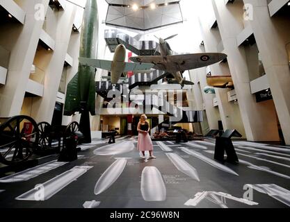 Ein Mitarbeiter des Imperial war Museum steht auf einem Teil der Oberfläche von Ai Weiweis 'Geschichte der Bomben' während einer Fotoausstellung für das neue Werk des chinesischen Künstlers, die im Imperial war Museum in London zu sehen ist. Das Kunstwerk zeigt 50 maßstabsgemaßte Bomben vom Ersten Weltkrieg bis in die Gegenwart und deckt die Böden und Wände des IWM-Atriums auf einer Fläche von über 1,000 Quadratmetern ab. Stockfoto