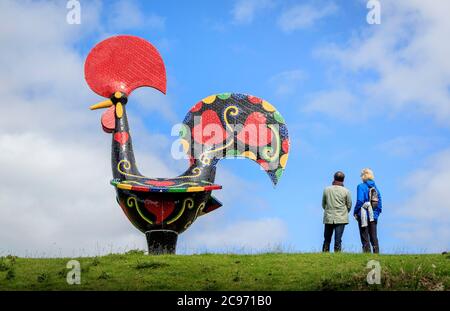 Die Besucher betrachten ein Werk mit dem Titel "Pop Galo" der Künstlerin Joana Vasconcelos als den Yorkshire Sculpture Park in Wakefield, Yorkshire, der heute wieder eröffnet wird, nachdem er seit Beginn der Coronavirus-Sperre geschlossen wurde. Stockfoto