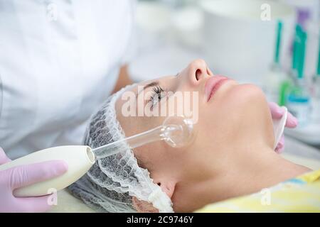 Frau bekommen Laser-Therapie in Spa. Frau erhalten Behandlungen in Schönheitssalons. Frau im Büro Kosmetikerin auf der Couch liegen. Stockfoto