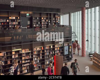 Oslo Norwegen erhielt 2020 ein neues öffentliches Bibliotheksgebäude. Deichman Bjørvika, geräumiges Interieur mit Büchern, Arbeitsplätzen und Besuchern Stockfoto
