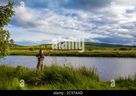 Ein Fischer Fliegenfischen in der Abendsonne auf dem Blackwater von Dee, Galloway, Schottland Stockfoto