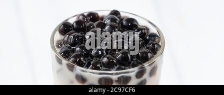 Bubble Milch Tee mit Tapioka Perle Belag, berühmte taiwanesische Getränk auf weißem Holztisch Hintergrund in Trinkglas, Nahaufnahme, kopieren Raum Stockfoto