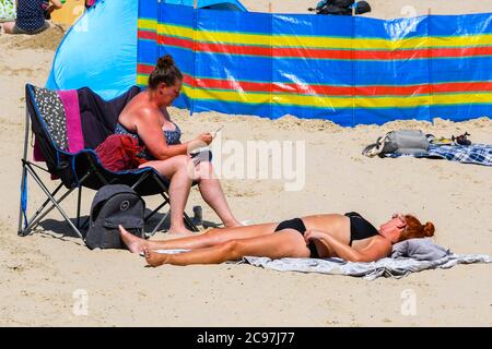 Weymouth, Dorset, Großbritannien. Juli 2020. Wetter in Großbritannien. Sonnenanbeter am Strand im Badeort Weymouth in Dorset an einem heißen, sonnigen Tag. Bild: Graham Hunt/Alamy Live News Stockfoto