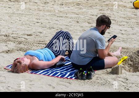 Weymouth, Dorset, Großbritannien. Juli 2020. Wetter in Großbritannien. Sonnenanbeter am Strand im Badeort Weymouth in Dorset an einem heißen, sonnigen Tag. Bild: Graham Hunt/Alamy Live News Stockfoto