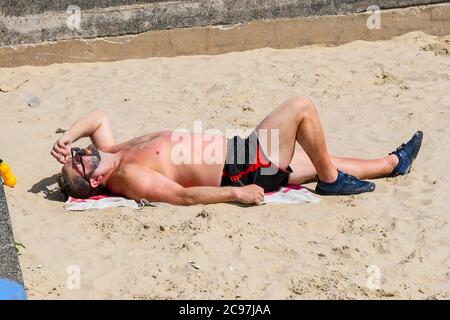 Weymouth, Dorset, Großbritannien. Juli 2020. Wetter in Großbritannien. Ein Sonnenbad am Strand im Badeort Weymouth in Dorset an einem heißen, sonnigen Tag. Bild: Graham Hunt/Alamy Live News Stockfoto