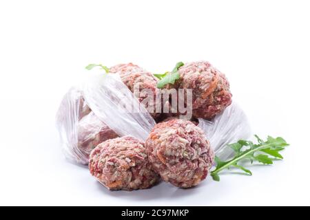 Gefrorene rohe Fleischbällchen aus Rind und Schweinefleisch mit Karotten und Reis isoliert auf weißem Hintergrund Stockfoto