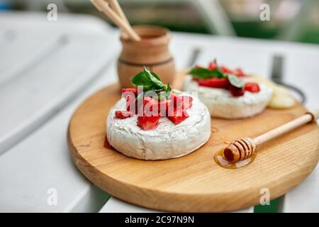 Gegrillter Camembert-Käse mit Erdbeere, Honig und Basilikumblättern, Delikatessen Stockfoto