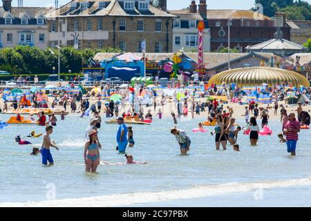 Weymouth, Dorset, Großbritannien. Juli 2020. Wetter in Großbritannien. Urlauber und Sonnenanbeter kühlen sich an einem heißen, sonnigen Tag im Meer am Strand des Badeortes Weymouth in Dorset ab. Bild: Graham Hunt/Alamy Live News Stockfoto