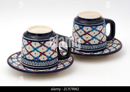 Tassen und Teller Kaffee mit einem traditionellen Design mit Ein weißer Hintergrund Stockfoto