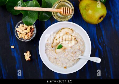 Eine Schüssel Haferbrei mit Birnen und Walnüssen. Stockfoto