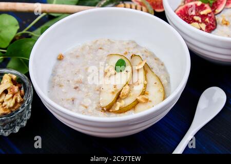 Eine Schüssel Haferbrei mit Birnen und Walnüssen. Stockfoto