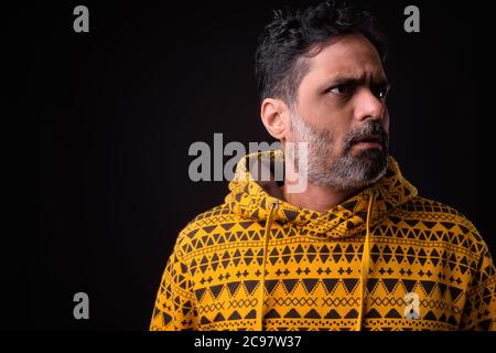 Portrait eines reifen bärtigen indischen Mannes mit lockigen Haaren und Kapuzenpullover Stockfoto