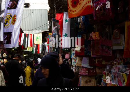 Damaskus/Syrien 03/29/2010: Al-Hamidiyah Souk (großer Basar im Zentrum von Damaskus) (Markthalle). Das Bild zeigt eine Reihe von Flaggen einschließlich syrischer FL Stockfoto