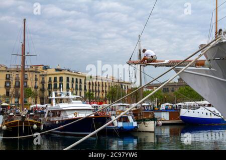 Barcelona, Spanien, 05/01/2010: Ein blick auf die Marina von Barcelona mit Booten und Yachten sowie Gebäuden an der Küste. Es sitzt ein Seemann Stockfoto