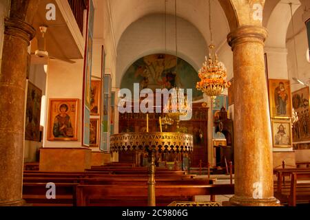 Madaba, Jordanien 04/03/2010: Im Inneren der griechisch-orthodoxen Kirche St. Georg, berühmt für seine umfangreiche Mosaikdekoration. Bild mit Säulen, Kronleuchter Stockfoto