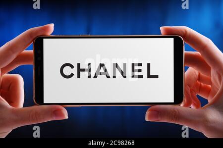 POZNAN, POL - JUN 12, 2020: Hand halten Smartphone mit Logo von Chanel, ein Luxus-Unternehmen, das sich auf High-Fashion und Ready-made Kleidung, l Stockfoto