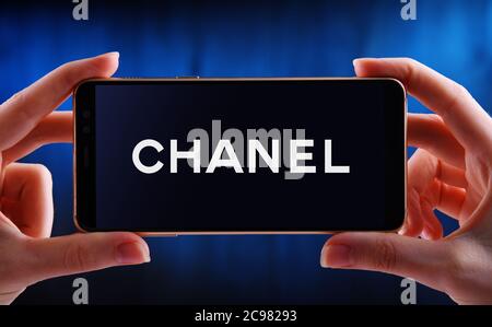 POZNAN, POL - JUN 12, 2020: Hand halten Smartphone mit Logo von Chanel, ein Luxus-Unternehmen, das sich auf High-Fashion und Ready-made Kleidung, l Stockfoto