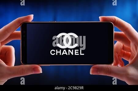 POZNAN, POL - JUN 12, 2020: Hand halten Smartphone mit Logo von Chanel, ein Luxus-Unternehmen, das sich auf High-Fashion und Ready-made Kleidung, l Stockfoto