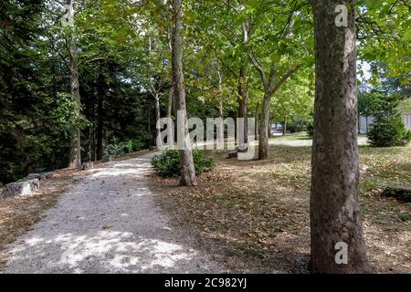 Schotterweg in einem bewaldeten Park um Spanisches Fort in der Stadt Aquila, Gemeinde L´aquila, Region Abruzzen, Italien Stockfoto