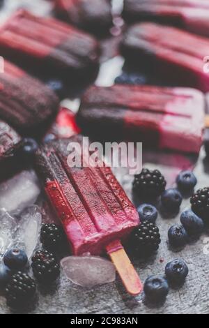 Hausgemachtes Brombeere- und Speiseeis oder Eis mit gefrorenen Beeren auf schwarzem Schiefertablett Stockfoto