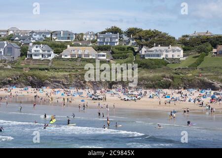 Polzeath, Cornwall, Großbritannien. Juli 2020. Wetter in Großbritannien. Surfer und Urlauber packten in das Wasser ein Strand in Polzeath als die Temperaturen beginnen zu steigen, vor der vorhergesagten Hitzewelle am Ende der Woche. Kredit Simon Maycock / Alamy Live Nachrichten. Stockfoto