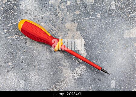 Standardschraubendreher mit Gehäusespitze, ergonomisch gestaltet, effizientes Handwerkzeug zum Drehen von Schrauben, isolierte Nahaufnahme auf rustikalem Hintergrund Stockfoto