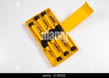 Ein Satz flacher und kreuzschlitzschraubendreher mit Isolator, magnetisch und mit rotem und gelbem und schwarzem Griff in einer Box Stockfoto