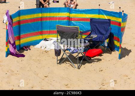 Windbreak / Windbreak errichtet von Touristenfamilie an einem windigen Tag am Bournemouth Strand in Dorset. VEREINIGTES KÖNIGREICH (120) Stockfoto